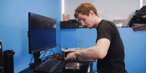 a man in a black shirt is working on a keyboard