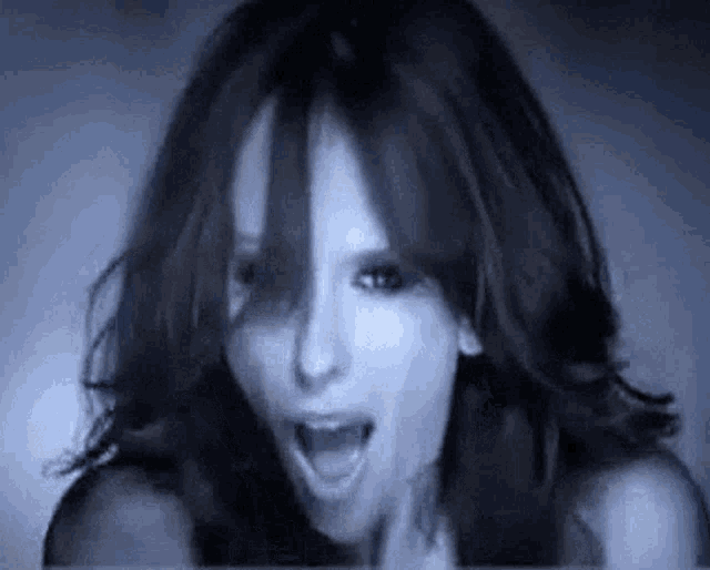 a close up of a woman 's face with her mouth open in a dark room .