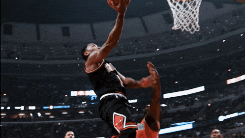 a basketball player jumps in the air to dunk a basketball