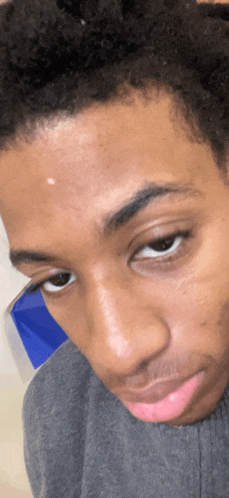 a close up of a person 's face with a red spot on their forehead