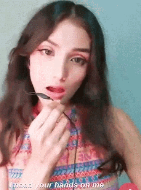 a woman is holding a spoon in her mouth with the words " i need your hands on me " below her