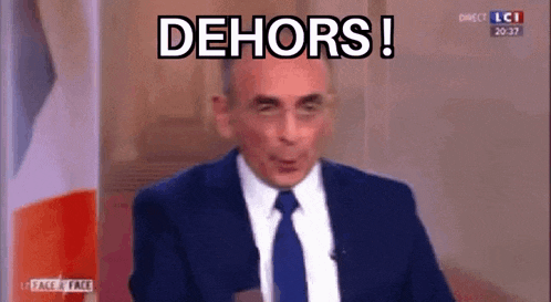 a man in a suit and tie is sitting in front of a flag and says `` dehors '' .