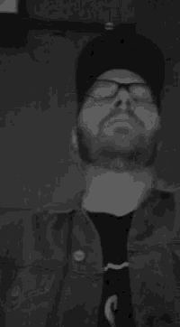 a man with glasses and a beard wearing a hat