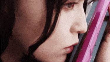 a close up of a woman holding a pink cell phone