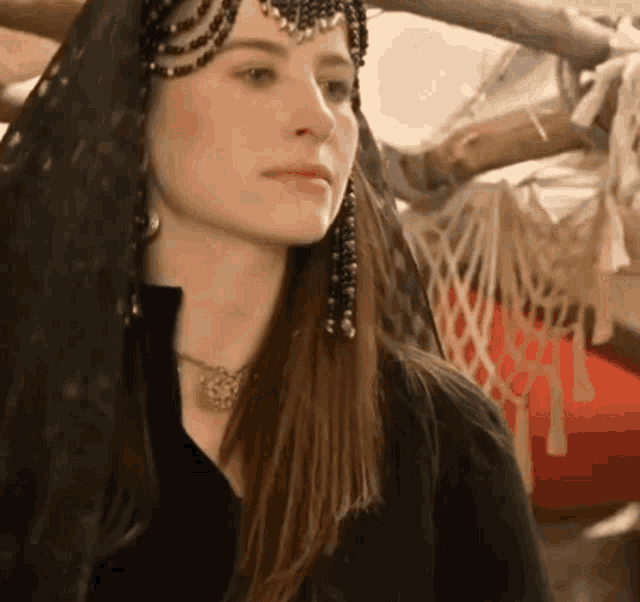 a close up of a woman wearing a black veil and a headpiece .
