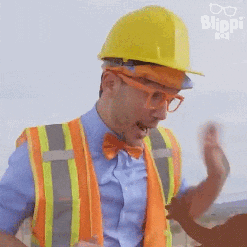 a man wearing a hard hat , vest , and bow tie is dancing .