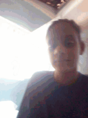a blurry picture of a person 's face with the sun shining through the window behind them