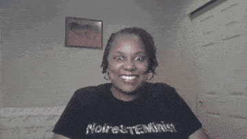 a woman wearing a black shirt that says noire reminiscence