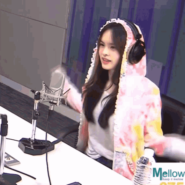 a woman wearing headphones stands in front of a microphone with the word mellow on the bottom