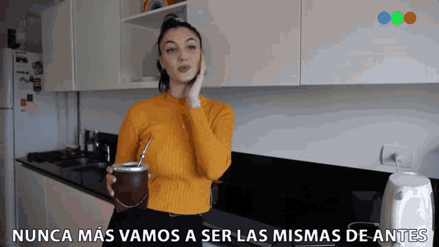 a woman in a yellow sweater is holding a cup with a straw in her hand and says nunca mas