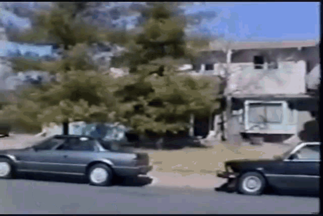 a couple of cars are parked on the side of the road in front of a building .