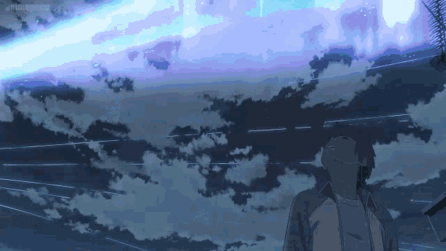 a man stands in front of a blue sky with a few clouds