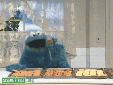 cookie monster from sesame street eating a cookie from a tray
