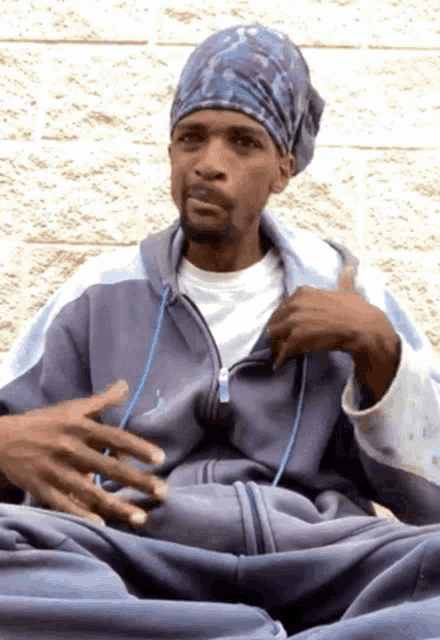 a man wearing a headband and a jordan jacket is sitting down