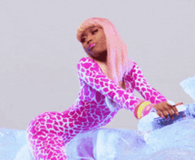 a woman with pink hair is sitting on a blue blanket