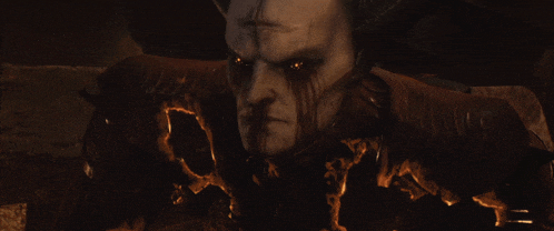 a demon with horns and red eyes looks at the camera