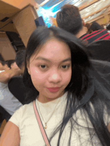 a woman with long black hair is taking a selfie with her hair blowing in the wind