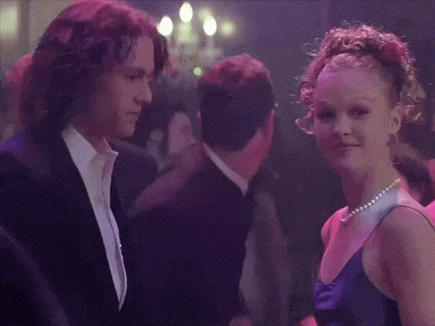 a man in a suit and a woman in a blue dress are dancing in a club