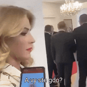 a woman holding a cell phone with the words a vy ste gdo