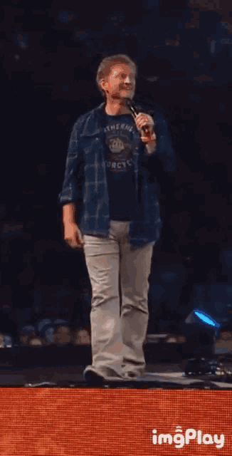 a man in a shirt that says arctic is dancing on stage