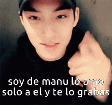 a young man is pointing at the camera with the words soy de manu lo amo solo a el y te lo grabas below him .