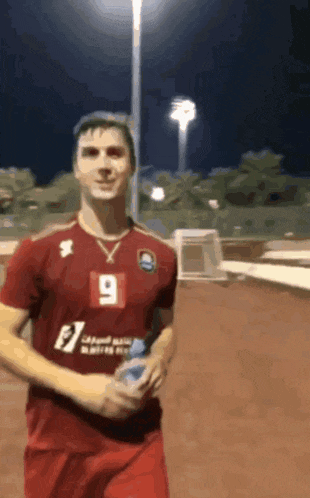 a man wearing a red jersey with the number 9 on the front