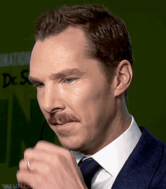 a man with a mustache is wearing a ring