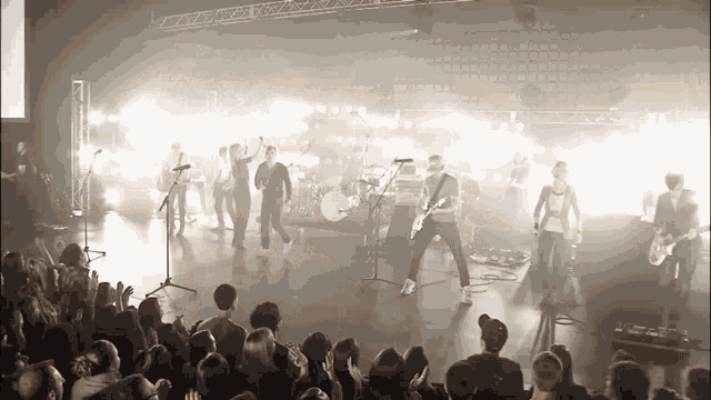 a group of people are playing instruments on a stage