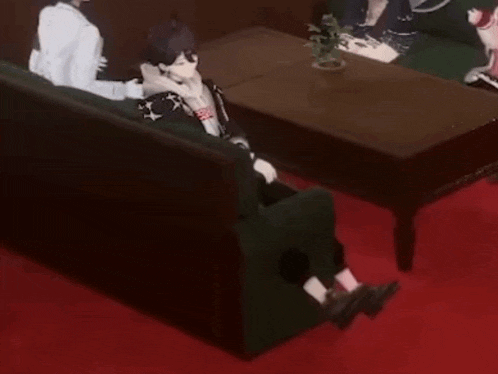 a person is sitting on a couch in a living room next to a coffee table .