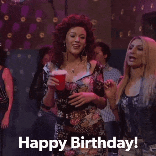 a woman in a floral dress holds up a red cup with the words happy birthday written below her