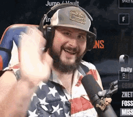 a man with a beard wearing headphones and an american flag shirt