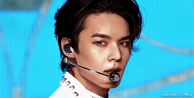 a close up of a man 's face with a microphone in his ear