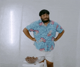 a man wearing a blue shirt with pineapples on it