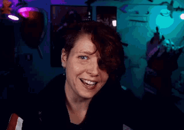 a woman with short red hair is crying and holding her hand to her face