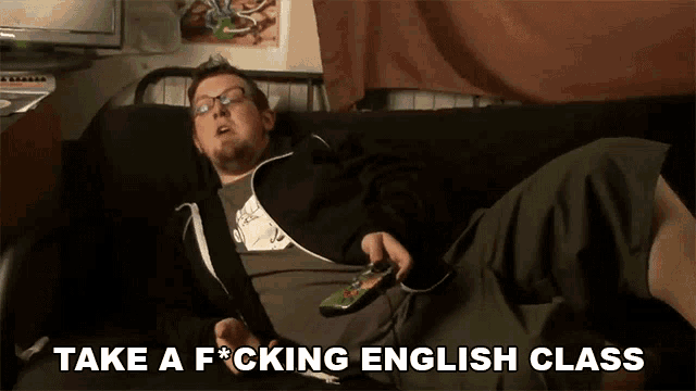 a man laying on a couch with the words take a f * cking english class