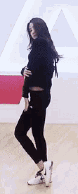 a woman is dancing on a wooden floor in a dance studio .