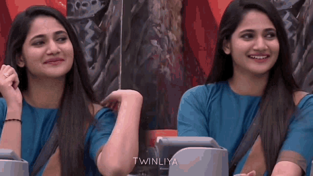 two women in blue shirts are sitting next to each other with twinliya written on the bottom