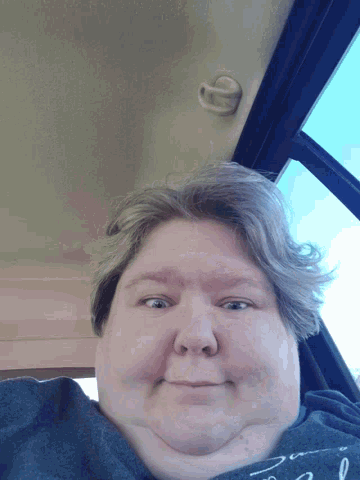 a woman 's face is shown from the back of a vehicle