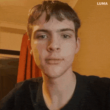 a close up of a young man 's face with luma written on the bottom