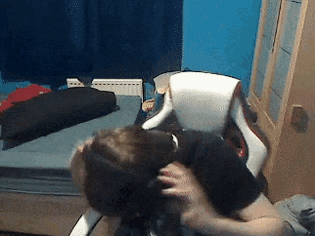 a person is sitting in a chair in a bedroom