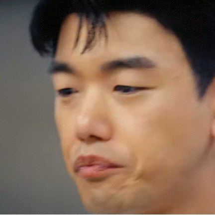a close up of a man 's face with a slight smirk on his face .