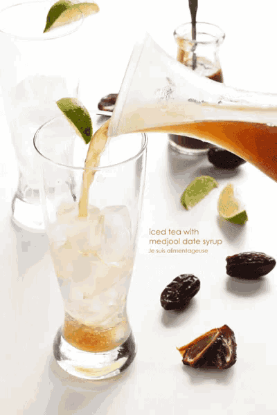 iced tea is being poured into a tall glass