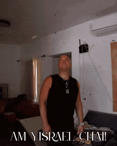 a man in a black tank top stands in a room with the words am yisrael chai on the bottom