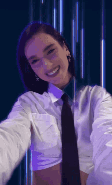 a woman wearing a white shirt and tie is smiling