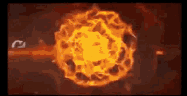 a fireball is exploding in the dark on a black background .