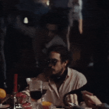 a man sits at a table with glasses of wine