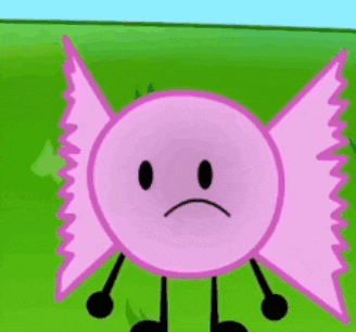 a pink candy with a sad face and arms and legs is standing on a green field .