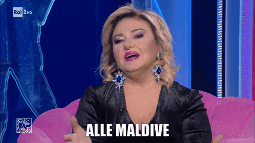 a woman sitting on a pink couch with the word alle maldive written on her face