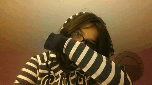 a girl wearing a black and white striped hoodie with the word pink on it