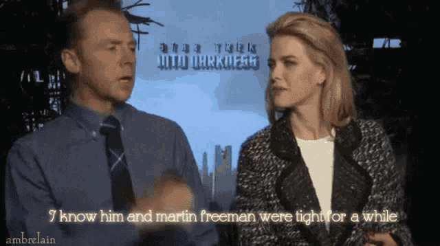 a man and a woman are talking in front of a star trek sign